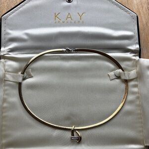 Kay Jewelers gold omega necklace with a heart-shaped diamond slide pendant.